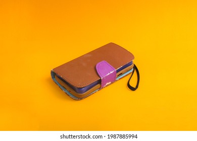 Old used brown case isolated on orange background