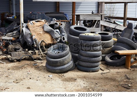 Old used car tires at a junkyard. Rubber tire recycling. 