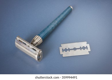 An old used double-edged safety razor for shaving and blade 