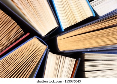 Old and used hardback books or text books seen from above. Books and reading are essential for self improvement, gaining knowledge and success in our careers, business and personal lives  - Shutterstock ID 153076043