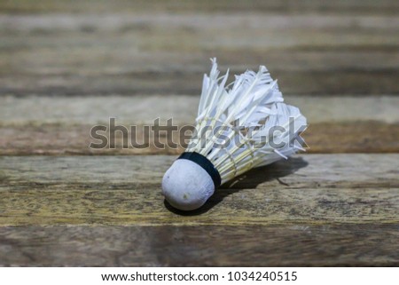 Old or used shuttlecock on wooden board background. Badminton sport concept