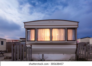 Old vacation home trailer illuminated at dusk. Trailer park in Holland, Netherlands