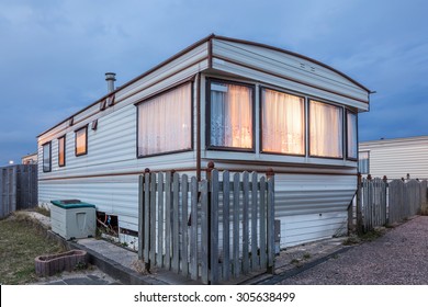 Old Vacation Home Trailer Illuminated At Dusk. Trailer Park In Holland, Netherlands