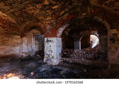Old vaulted red brick cellar under abandoned building.