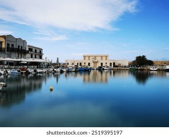 Old Venetian Port of Rethymno by daylight. Blurred sea. silky water effect. Blue Sky, white Clouds. little Fishing boats. yellow buoy, Background
 - Powered by Shutterstock