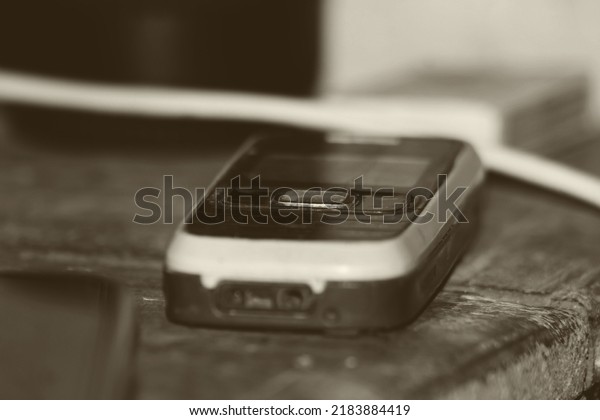 An old version keypad\
mobile phone on the table. Closeup or high magnification view Copy\
space.