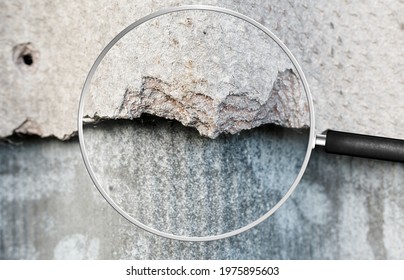 Old and very dangerous asbestos roof. Asbestos dust in the environment. Health problems. View through magnifying glass