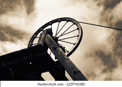 Old Victorian coal shaft tower and wheel pulley with colour toning