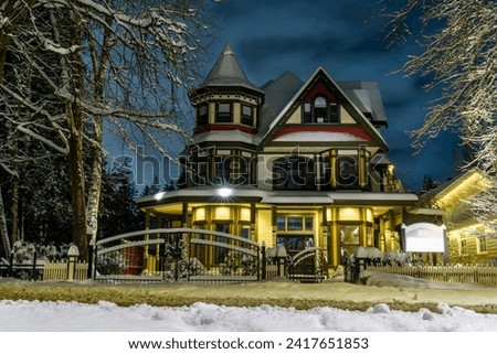 Old Victorian style house during Christmas time with winter decorations. Outdoor Christmas landscape in the snow. Night shot HDR landscape. Dreamy and utterly silent vibe.