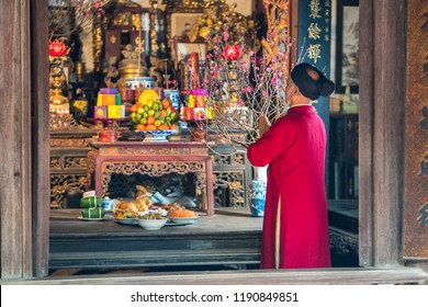 Old Vietnamese man preparing altar with foods for the last meal of year. The penultimate New Years Eve - Tat Nien, the meal finishing the entire year. Vietnam lunar new year.