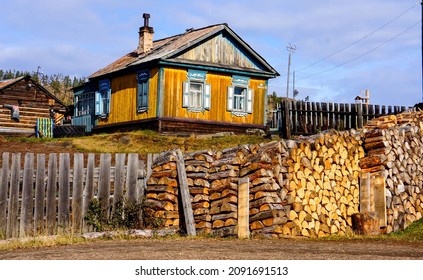 An old village house with a woodpile in Russia