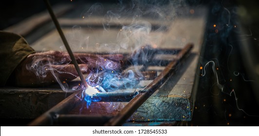 Old Village Welding Workshop. Elderly Man Working With Metal And Welding Electrode