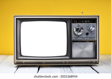 An Old Vintage 1970s Television With A White Isolated Screen For Adding Videos And Images Stands On A Wooden Table Against A Yellow Background. Vintage TVs 1970s 1980s 1990s 2000s. 