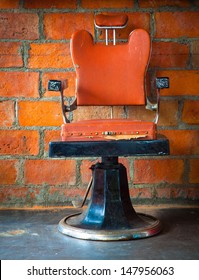 The Old Vintage Barber Chair Over Brick Wall