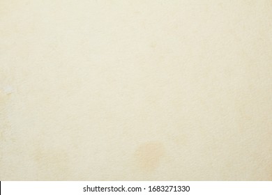 Old vintage beige sheet of drawing paper with dirty stains and spots on surface texture background.