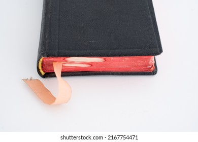 Old Vintage Black Closed Hardcover Book With A Satin Bookmark. Close Up Shot, Shallow Depth Of Field, White Background, No People