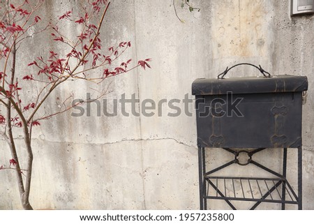Old vintage black mailbox on the background of a concrete wall.