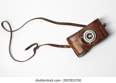 Old vintage camera with 35mm lens in brown leather case isolated on white background