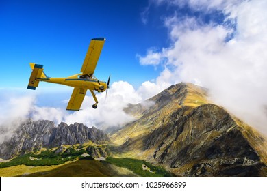 Old and vintage Cessna 172 airplane flying above Carpathian mountain peaks in Romania