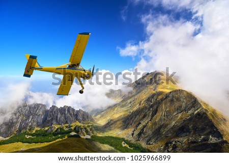 Old and vintage Cessna 172 airplane flying above Carpathian mountain peaks in Romania