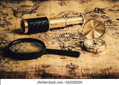 Old vintage compass ,telescope and magnifying glass on vintage map