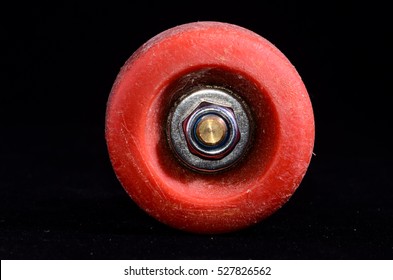 Old Vintage Consumed Skate Wheel On A Black Background