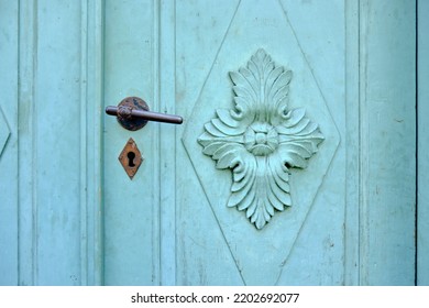 Old Vintage Door Hardware On A Green Door With Ornate Coffered Panel.