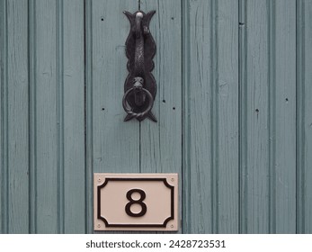 Old Vintage French Door Handle with the number 8 on the door. Wooden door with iron handle and knocker - Powered by Shutterstock