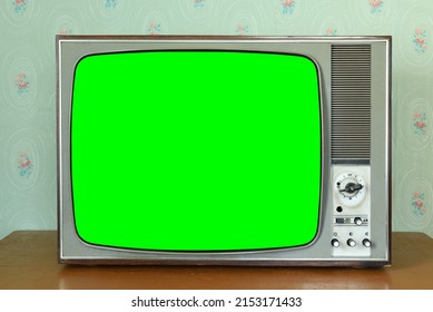 Old vintage green screen TV in a room with vintage wallpaper. Interior in the style of the 1960s. - Shutterstock ID 2153171433