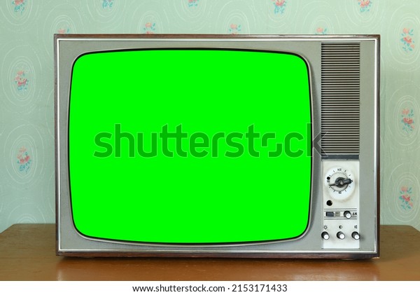 Old vintage green screen TV in\
a room with vintage wallpaper. Interior in the style of the\
1960s.