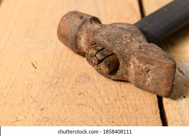 Old vintage hammer closeup on a wooden background, household hand tools