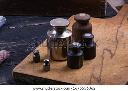old vintage iron weights for weighing goods on a wooden background