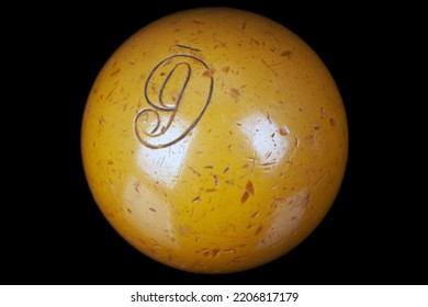 Old vintage ivory billiard ball, number nine. On black background