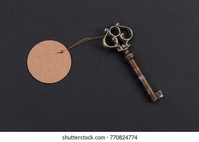 Old Vintage Key With Blank Empty Tag Or Label On Black Background As Hotel And Real Estate Concept