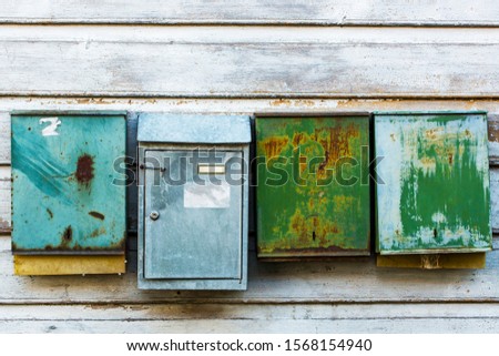 Old an vintage mailboxes with rusty metallic texture on wooden exterior wall background.