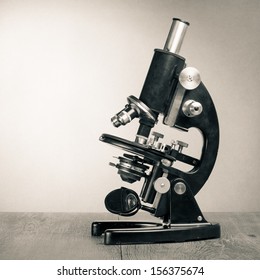 Old vintage microscope on table sepia photo