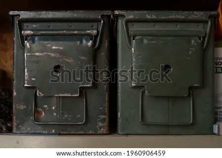 old vintage military ammo cans metal storage containers sitting on the shelf collecting dust olive dab green