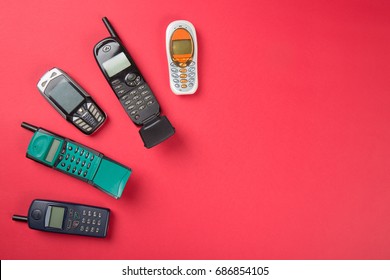 Old vintage mobile phones on red background.
