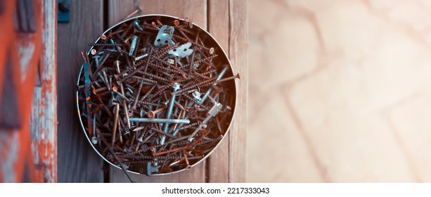 Old Vintage Nails In A Round Box Lie On The Porch Of A Wooden Country House, Top View. Old Things For Workshop And Recycling And Creative Work.