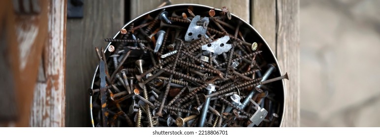 Old Vintage Nails In A Round Box Lie On The Porch Of A Wooden Country House, Top View. Old Things For Workshop And Recycling And Creative Work.