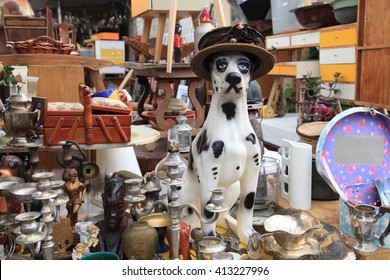 Old vintage objects and furniture for sale at a flea market. Toy vintage dog. Selective focus
