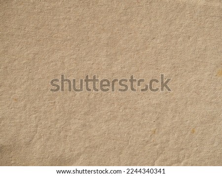 Old vintage paper background texture. Close-up of brown cardboard paper with a rough fibrous texture of the background surface