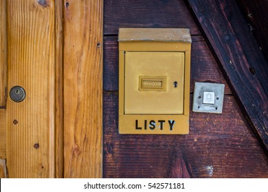 Old vintage Polish post box (box for letters - listy) and a door bell, hanged on the old wooden wall near to the doors. - Shutterstock ID 542571181