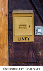 Old vintage Polish post box (box for letters - listy) and a door bell, hanged on the old wooden wall near to the doors. - Shutterstock ID 542571184