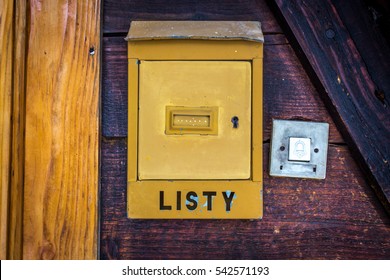 Old vintage Polish post box (box for letters - listy) and a door bell, hanged on the old wooden wall near to the doors. - Shutterstock ID 542571193