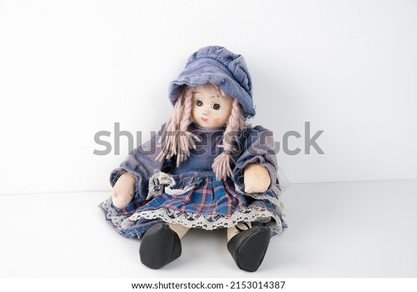 Old vintage rag doll in a\
dress.