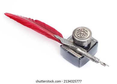 Old vintage red fountain pen with inkwell on white background