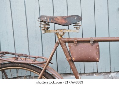 old vintage rusty bicycle, bike saddle, saddle bag and trunk on the background of a wooden fence close-up - Powered by Shutterstock