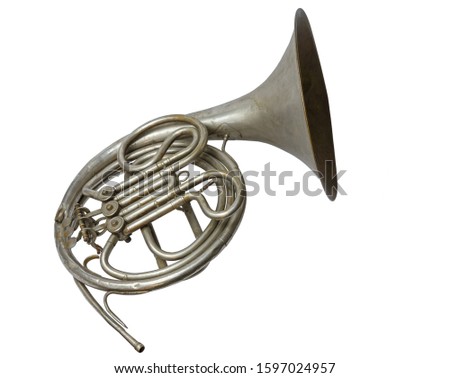 Old vintage silver French horn on a white background, isolated