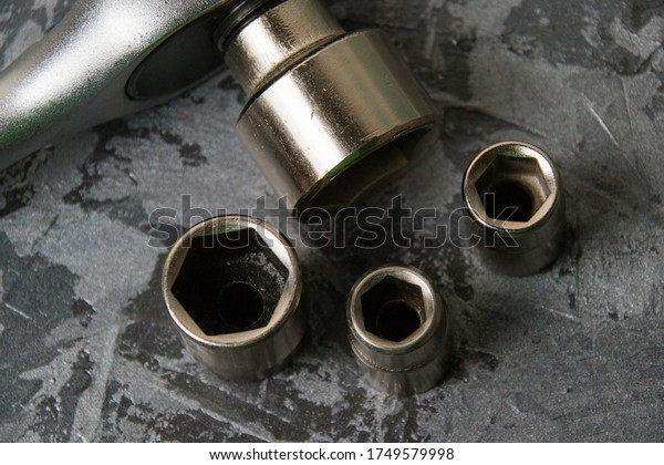 Old vintage\
socket wrench with ratchet and different nozzles close-up on a dark\
gray background with place for\
text